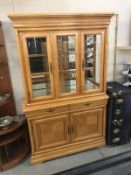 A light oak display cabinet on cupboard base.