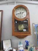 A 1930's arch top wall clock with silvered dial and bevelled glass panel