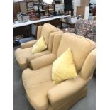 A pair of yellow fabric armchairs