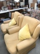 A pair of yellow fabric armchairs