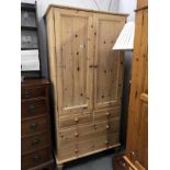 A solid pine double wardrobe on 4 drawer base.