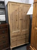 A solid pine double wardrobe on 4 drawer base.