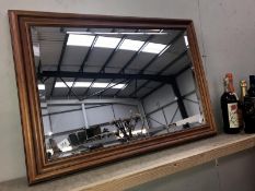 A dark wood stained bevel edged mirror.