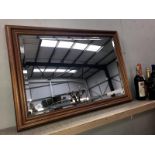 A dark wood stained bevel edged mirror.