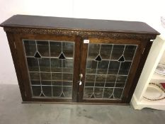 An oak bookcase with leaded glass doors