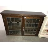 An oak bookcase with leaded glass doors