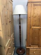 A dark wood stained standard lamp with shade.