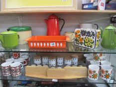 2 shelves of kitchenalia including enamel jugs, pans, flower power mugs etc.
