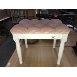 A plush pink dressing table stool