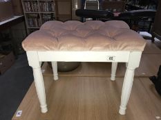 A plush pink dressing table stool