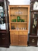 A solid pine open bookcase on cupboard/drawer base