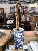 A blue & white stick/umbrella stand & contents