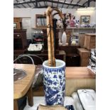 A blue & white stick/umbrella stand & contents