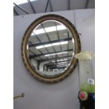 An oval gilt framed bevel edged mirror