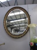 An oval gilt framed bevel edged mirror