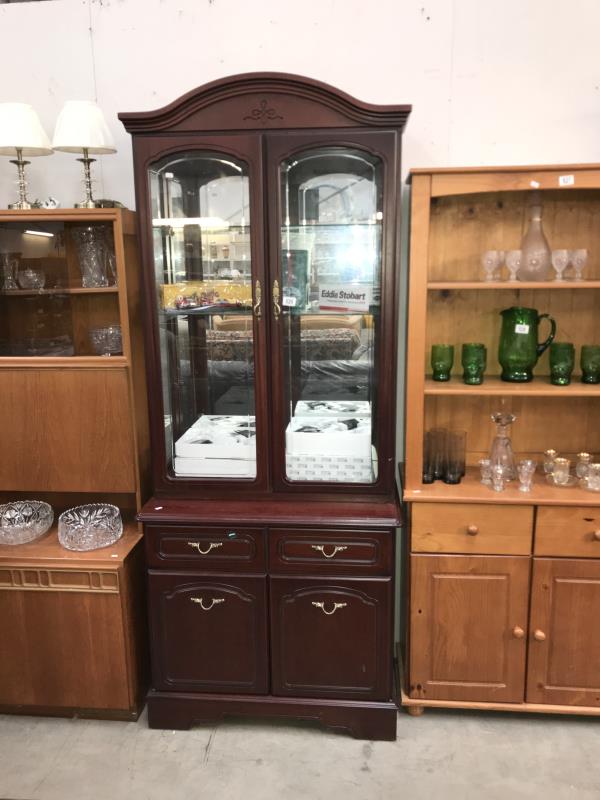 A dark wood stained glazed display cabinet on cupboard/drawer base
