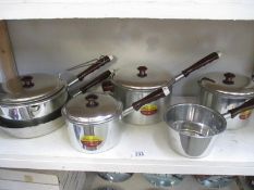 A quantity of vintage stainless steel saucepans