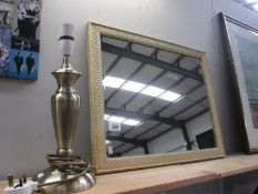 A framed mirror and table lamp