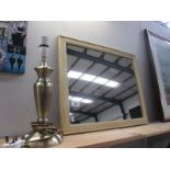 A framed mirror and table lamp