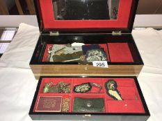 A wooden jewellery box with oriental painted panels containing costume jewellery, rosaries,