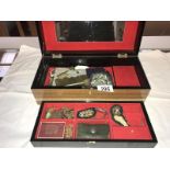 A wooden jewellery box with oriental painted panels containing costume jewellery, rosaries,