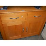 A light oak 2 door 2 drawer cupboard