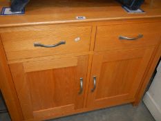 A light oak 2 door 2 drawer cupboard