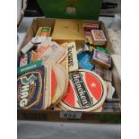 A tray of match boxes and a quantity of beer mats