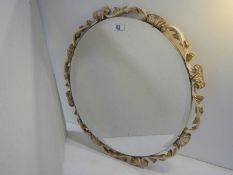 A carved wood guesso and guilded bevel edged circular mirror, no damage.