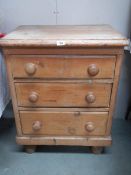 An antique 3 drawer pine chest on bun feet,