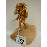 A small gilded figure of a mountain goat farmer standing on a rock, 5.5" tall.
