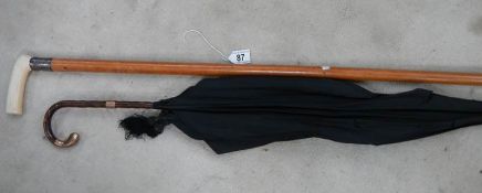 An old umbrella with 19th century mounts (a/f) and a walking stick with silver mounts.