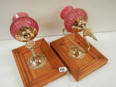 2 vintage bedside wall lamps with red shades.