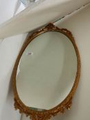 A gilt metal framed oval mirror, in good condition.