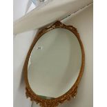 A gilt metal framed oval mirror, in good condition.