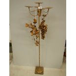 A tall gilded candle holder with embellishments, 43" tall.