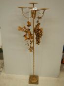 A tall gilded candle holder with embellishments, 43" tall.