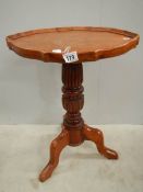 A teak oval tripod table