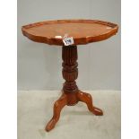 A teak oval tripod table