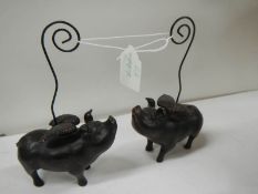 2 ceramic pocket watch stands in the form of flying pigs.