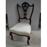 An Edwardian bedroom chair on brass casters, in good condition,