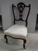 An Edwardian bedroom chair on brass casters, in good condition,