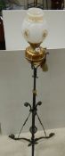 An early 20th century adjustable brass and iron standard oil lamp.