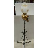 An early 20th century adjustable brass and iron standard oil lamp.