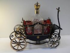 A 1950's musical.decanter stand in the form of a carriage complete with decanter and 4 glasses.