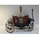 A 1950's musical.decanter stand in the form of a carriage complete with decanter and 4 glasses.