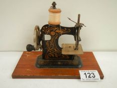 A miniature hand operated sewing machine, made in Germany.