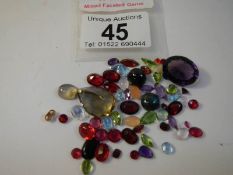 A mixed lot of loose gem stones including rubies, approximately 50 in total.