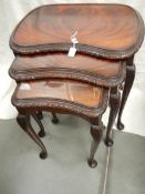 A nest of 3 mahogany tables on cabriole legs.