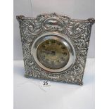 A good quality embossed silver plated mantel clock in good working order (8" wide x 8" high).